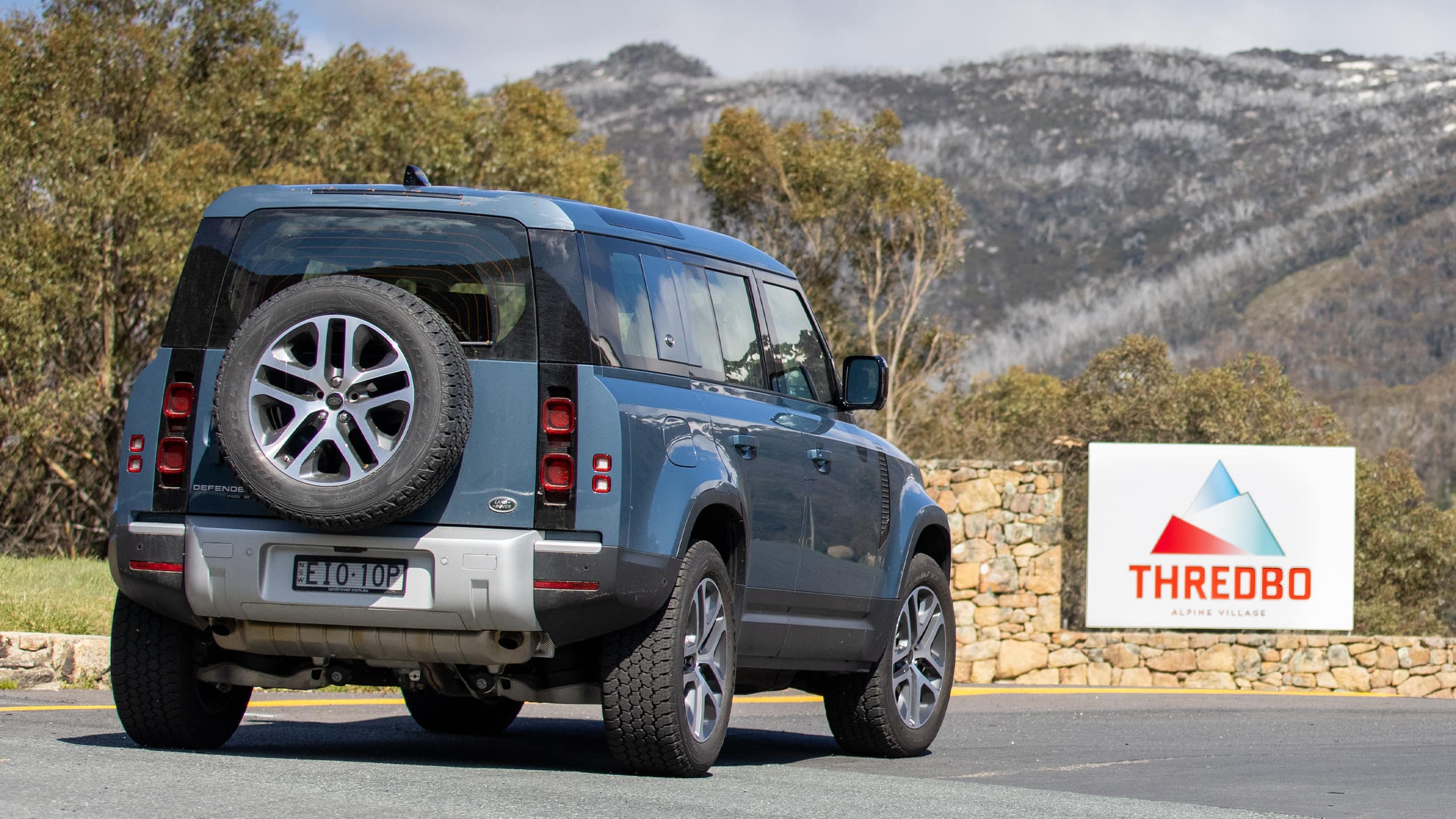 Land Rover Defender on the road near the Thredbo logo