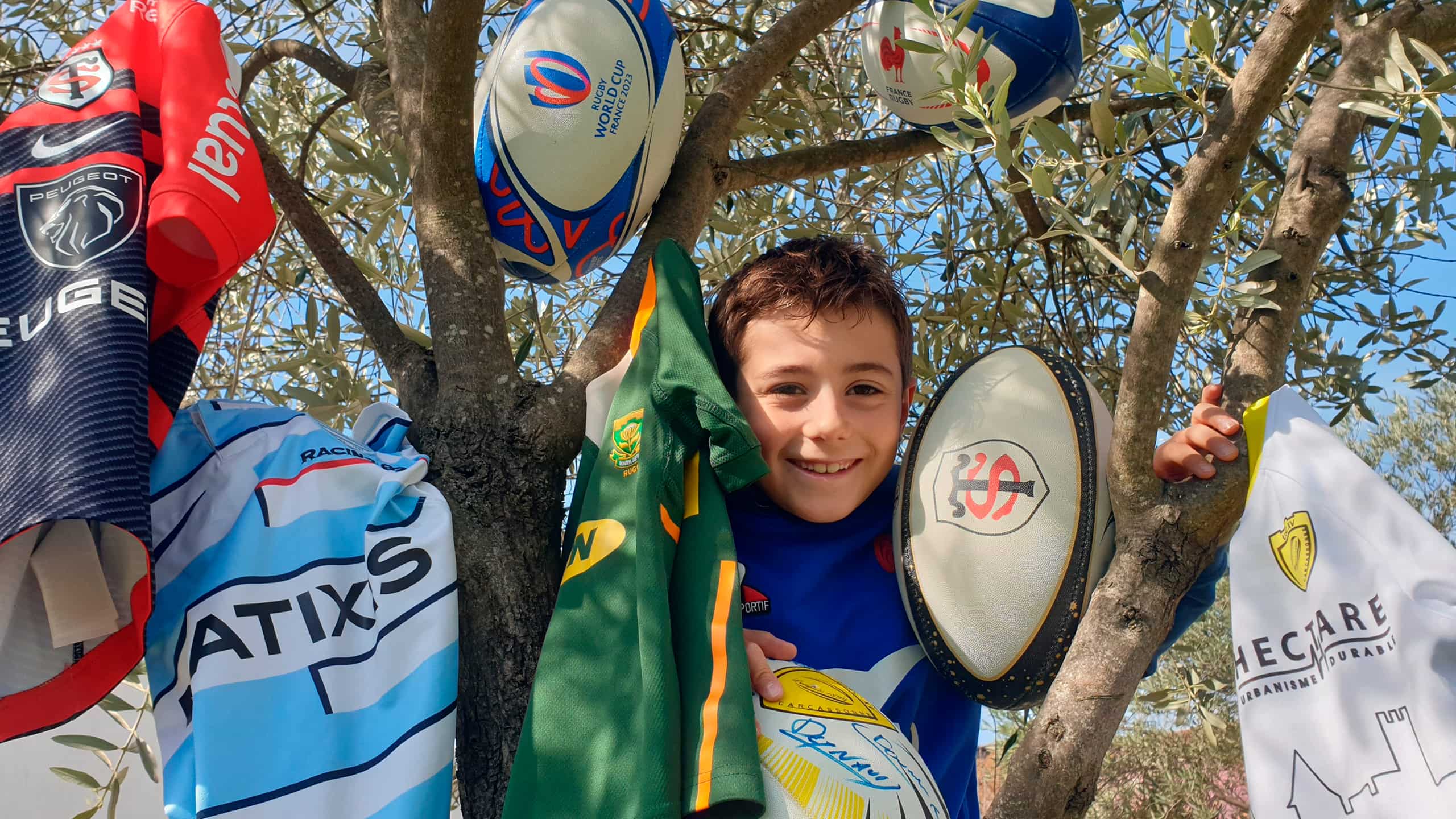 Happy boy posing for pic with Rugby equipments